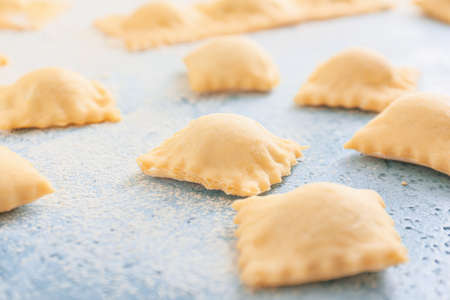 Uncooked ravioli on color backgroundの写真素材