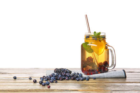 Mason jar of cold tea on table against white backgroundの写真素材