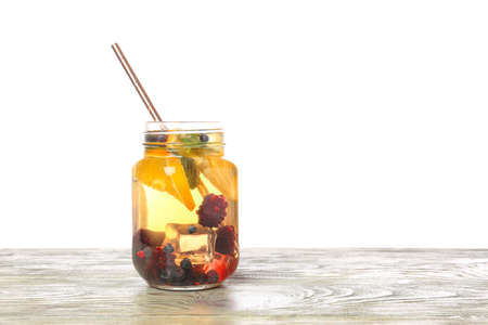 Mason jar of cold tea on table against white backgroundの写真素材