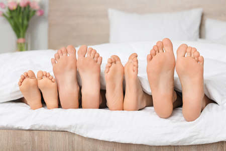 Family lying in bed at homeの写真素材