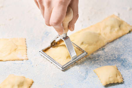 Woman preparing tasty ravioli on tableの写真素材