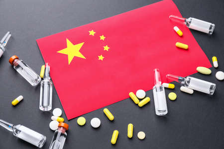 National flag of China and medicines for Coronavirus on dark backgroundの写真素材