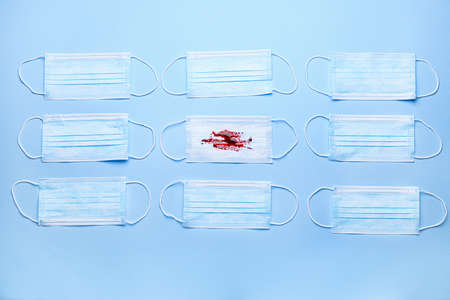 Protective masks with blood on color background. Concept of Coronavirusの写真素材