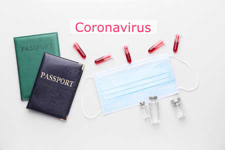Protective mask with passports, blood sample and vaccine for Coronavirus on white backgroundの写真素材