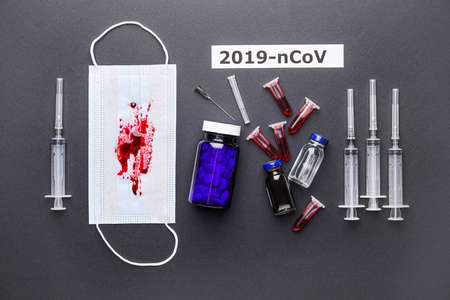 Protective mask with blood samples and medicines for Coronavirus on dark background