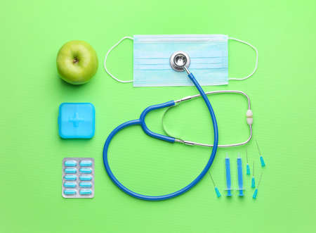 Set of medical supplies with apple on color backgroundの写真素材