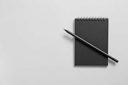Notebook with pencil on gray background