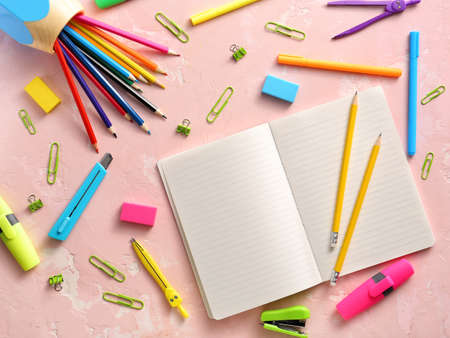 Notebook with school supplies on color backgroundの写真素材