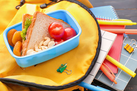 School lunch box and backpack on wooden backgroundの写真素材