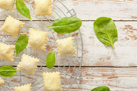 Raw ravioli with spinach on gridの写真素材