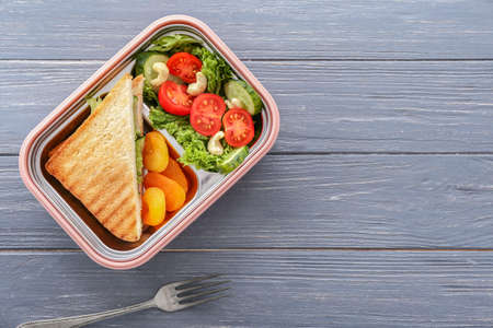 School lunch box with tasty food on wooden backgroundの写真素材