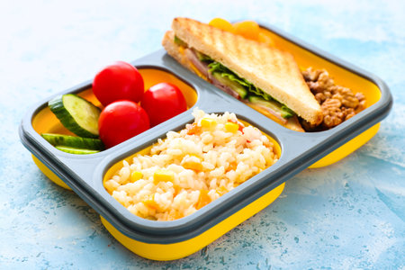 School lunch box with tasty food on color background