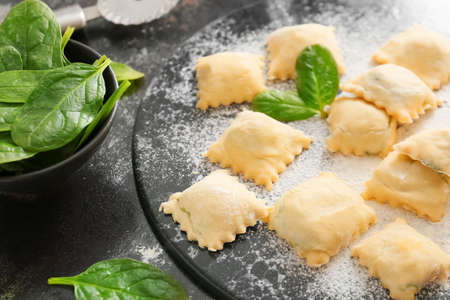 Raw ravioli with spinach on dark backgroundの写真素材