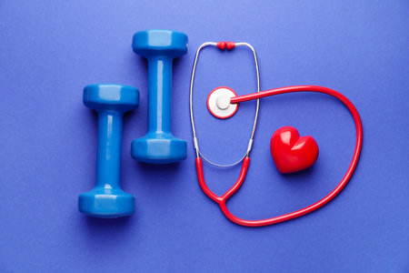 Stethoscope, heart and dumbbells on color backgroundの写真素材