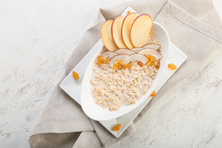 Bowl with tasty sweet oatmeal on white backgroundの写真素材