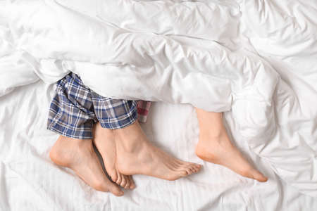 Young couple lying in bed, top viewの写真素材