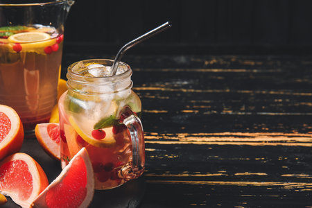 Mason jar of cold tea on dark wooden tableの写真素材