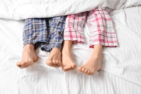 Young couple lying in bed, top viewの写真素材