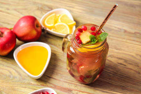 Mason jar of cold tea and ingredients on wooden tableの写真素材