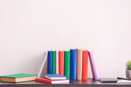 Many books on table near light wallの写真素材