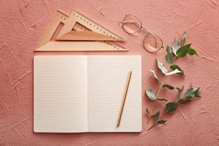 Notebook with rulers, pen eyeglasses on color backgroundの写真素材