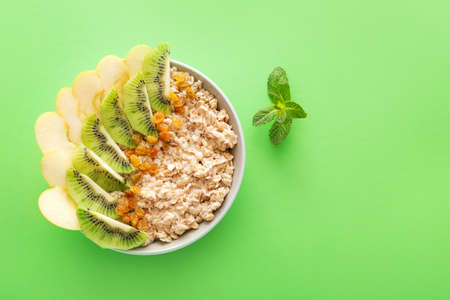 Bowl with tasty sweet oatmeal on color backgroundの写真素材