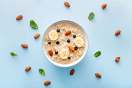Bowl with tasty sweet oatmeal on color backgroundの写真素材