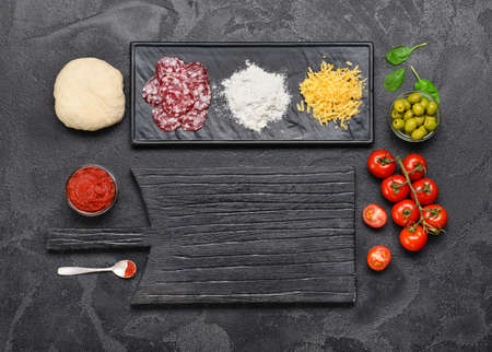 Ingredients for tasty pizza on dark backgroundの写真素材