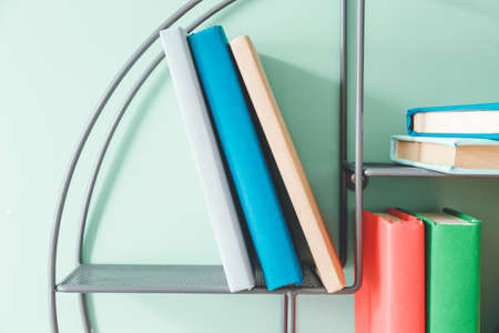Shelf with books on color wallの写真素材