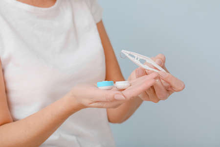 Mature woman with contact lenses against light background, closeupの写真素材