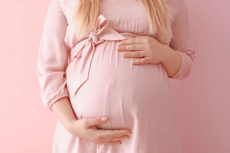 Beautiful pregnant woman on color backgroundの写真素材
