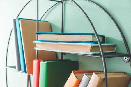 Shelf with books on color wallの写真素材