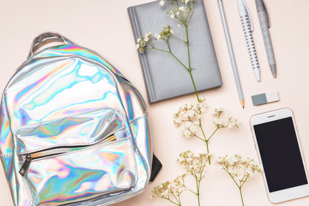 Set of school supplies with backpack and mobile phone on light backgroundの写真素材