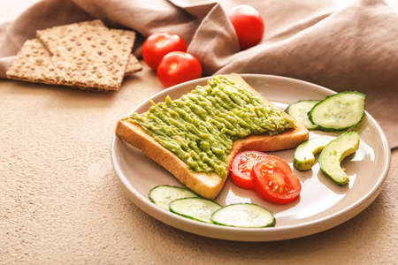Plate with tasty avocado sandwich on tableの写真素材