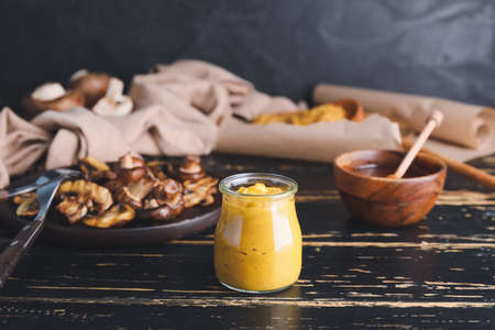 Jar of tasty honey mustard sauce on wooden tableの写真素材