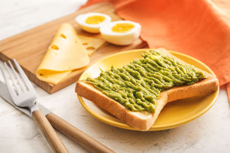 Plate with tasty avocado sandwich on tableの写真素材