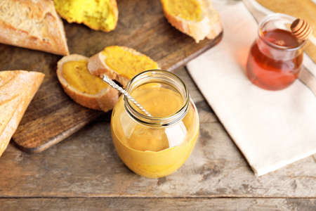 Jar of tasty honey mustard sauce on wooden tableの写真素材