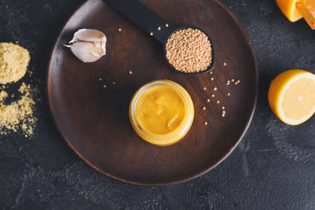 Jar of tasty honey mustard sauce on dark backgroundの写真素材