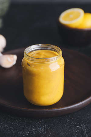 Jar of tasty honey mustard sauce on dark backgroundの写真素材