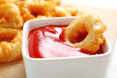 Crispy fried onion rings and tomato sauce on table, closeupの写真素材