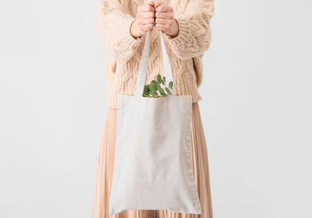 Woman with eco bag on light backgroundの写真素材