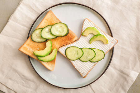 Plate with tasty avocado sandwiches on table