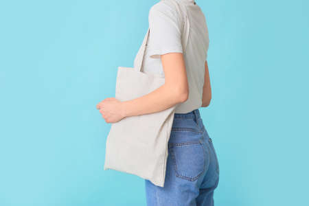 Woman with eco bag on color backgroundの写真素材
