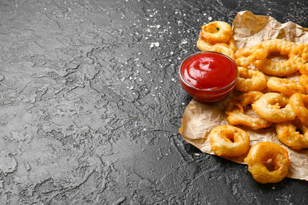 Crispy fried onion rings and sauce on tableの写真素材