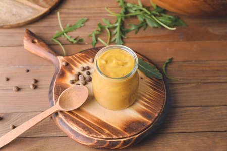 Jar of tasty honey mustard sauce on wooden tableの写真素材