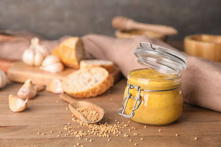 Jar of tasty honey mustard sauce on wooden tableの写真素材