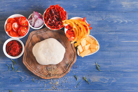 Ingredients for tasty pizza on color wooden backgroundの写真素材