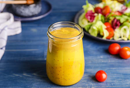 Jar of tasty honey mustard sauce on wooden tableの写真素材