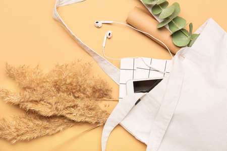 Eco bag with mobile phone and notebooks on color backgroundの写真素材