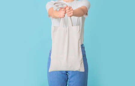 Woman with eco bag on color backgroundの写真素材